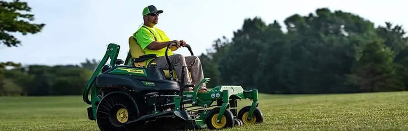 R.M. Landscape crew member operating commercial mowing equipment on a professionally maintained commercial property in Western New York.